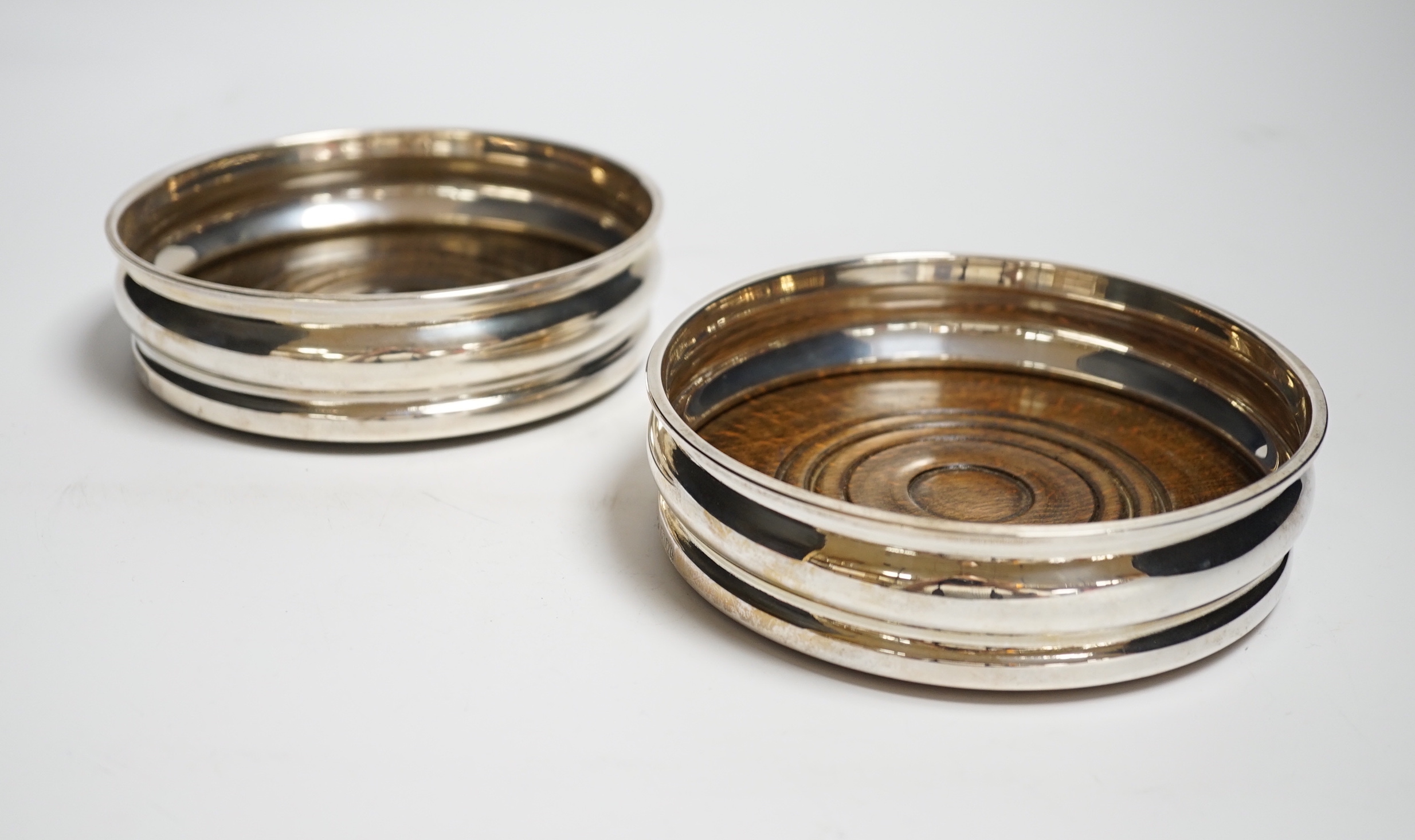 A pair of Elizabeth II silver mounted wine coasters, Nat Joseph, London, 1963, 13.4cm.